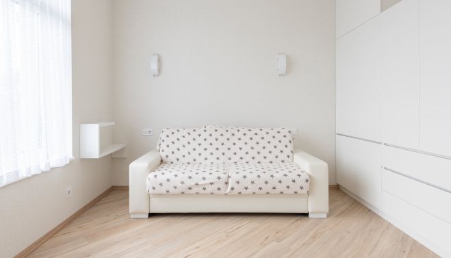 Light sofa in the center of a white room